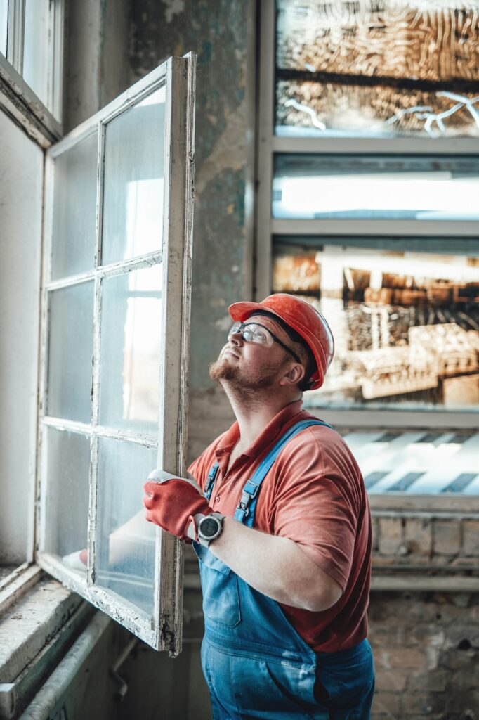 Builder working with a window at a construction site